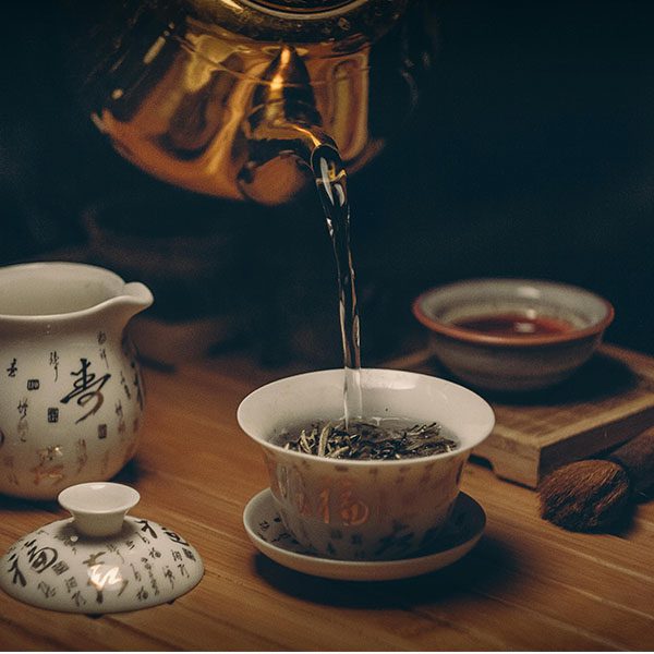 Préparation d'une infusion relaxante dans une vaisselle traditionnelle pour favoriser l'endormissement et un sommeil profond.